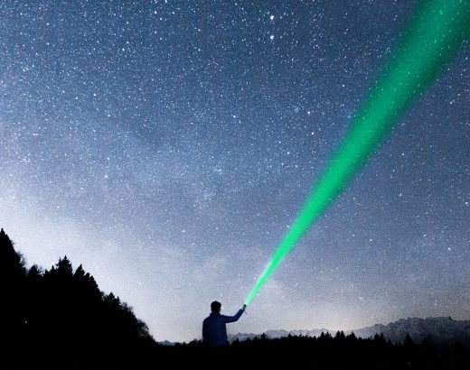 A man shines a torch into the starry sky in search of a "marketing strategy".