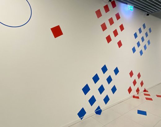 Des surfaces carrées en bleu et rouge forment un X qui provient du logo de MeluXina.