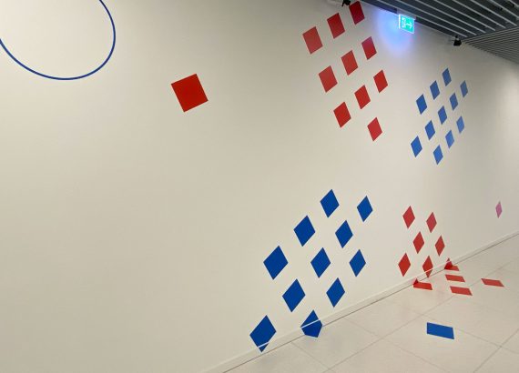Des surfaces carrées en bleu et rouge forment un X qui provient du logo de MeluXina.