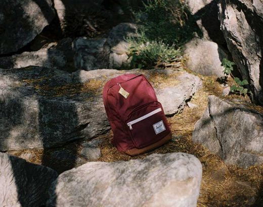 Das Bild zeigt einen roten Rucksack, der auf einem Felsen liegt.