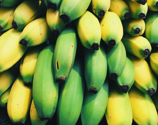 Das Bild zeigt eine Detailaufnahme von einem Haufen Bananen. Die Farben Gelb und Grün laufen teilweise ineinander über.