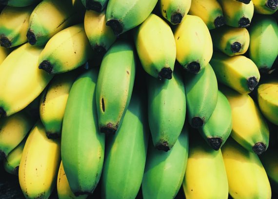 Das Bild zeigt eine Detailaufnahme von einem Haufen Bananen. Die Farben Gelb und Grün laufen teilweise ineinander über.